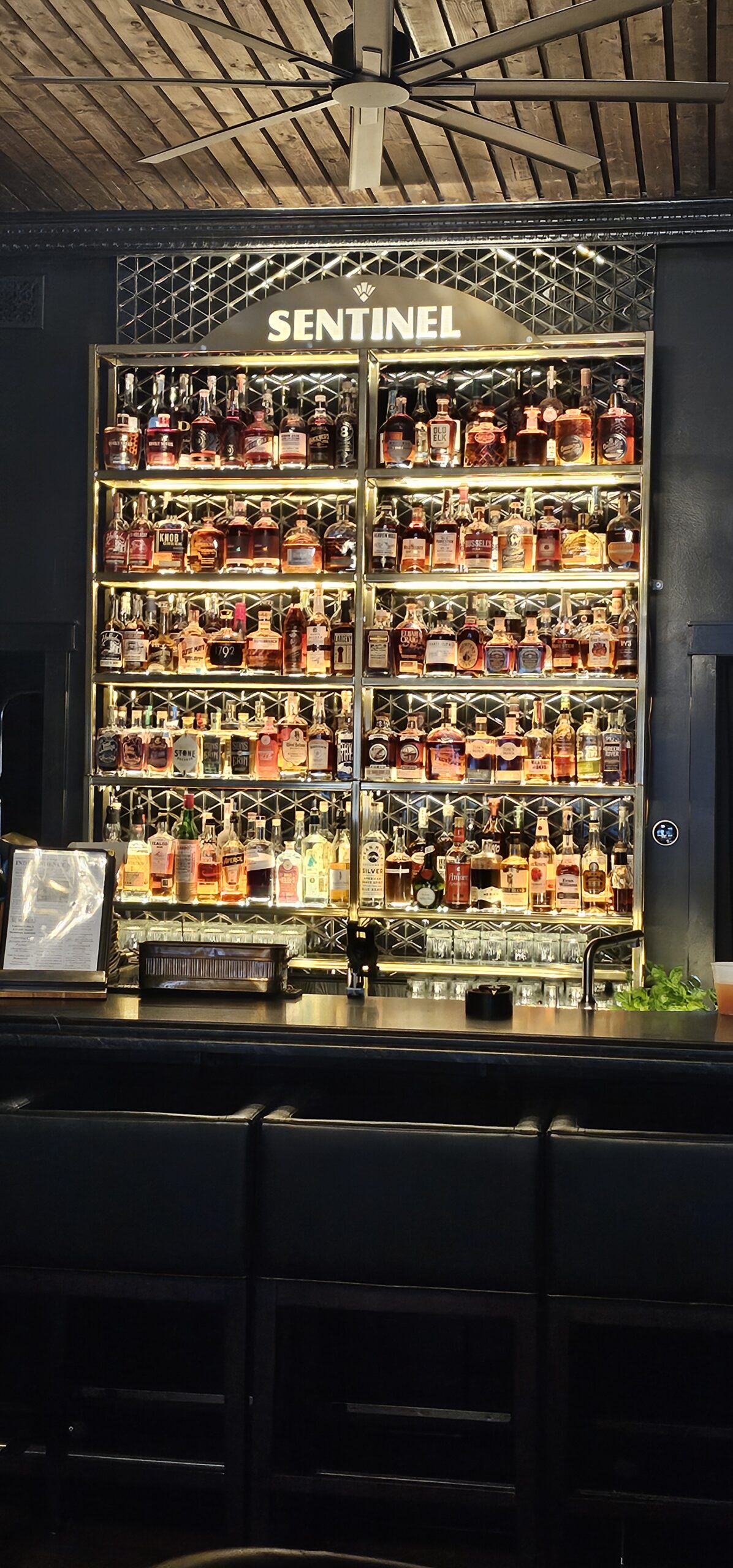 Bar with shelves of liquor bottles.